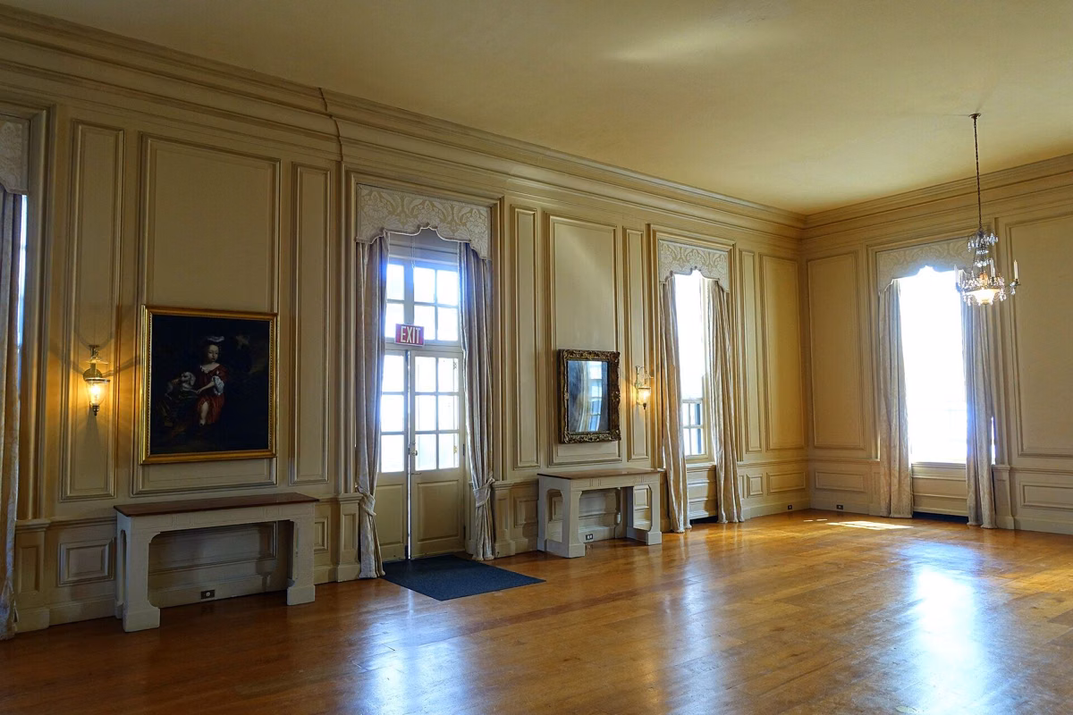 A paneled living room in the Great House with tall windows