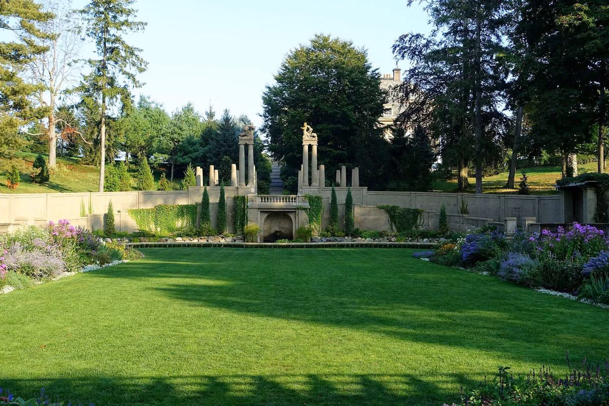 The Italian Garden at Castle Hill, with lawn, flower beds and stone columns