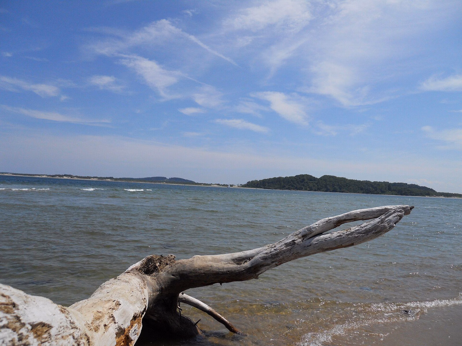 Ipswich Bay at full tide under a blue sky, with Crane Beach and Castle Hill across the water