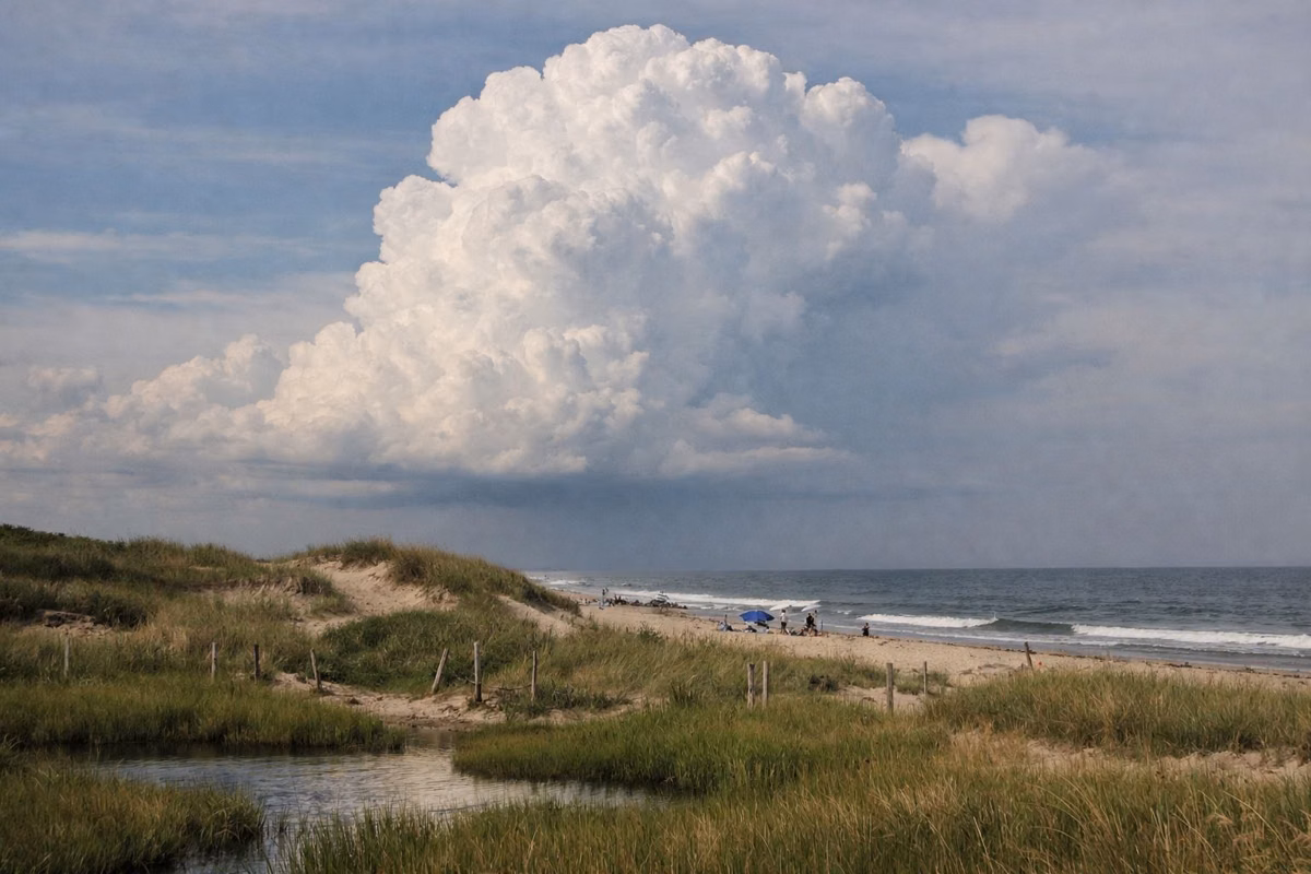 A thunderhead building over the dunes and beach